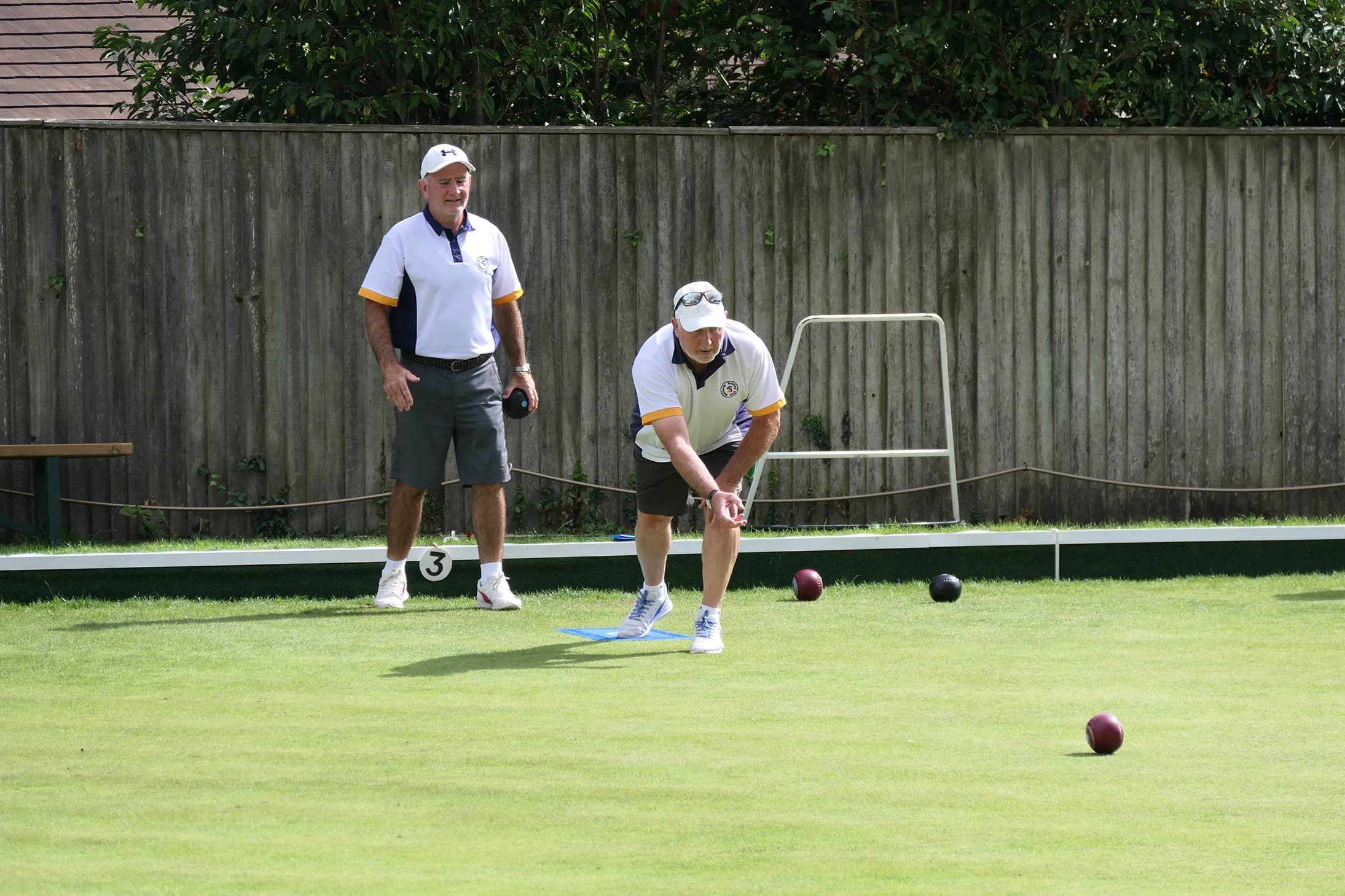 Two Midhurst Bowling Club members playing on the club's green
